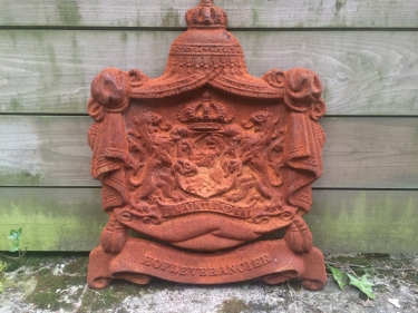 Gietijzeren wandornament, zwaar uitgevoerd met de spreuk: Je maintiendrai (ik zal handhaven), hofleverancier