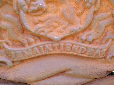 Gietijzeren wandornament, zwaar uitgevoerd met de spreuk: Je maintiendrai (ik zal handhaven), hofleverancier