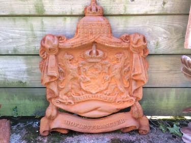 Gietijzeren wandornament, zwaar uitgevoerd met de spreuk: Je maintiendrai (ik zal handhaven), hofleverancier