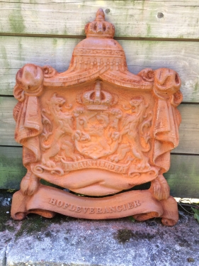 Gietijzeren wandornament, zwaar uitgevoerd met de spreuk: Je maintiendrai (ik zal handhaven), hofleverancier