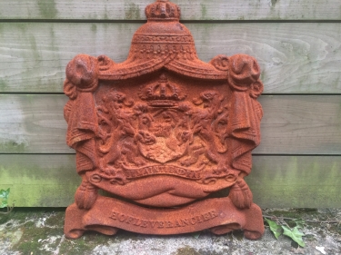 Gietijzeren wandornament, zwaar uitgevoerd met de spreuk: Je maintiendrai (ik zal handhaven), hofleverancier