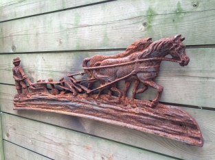 Wanddecoratie , gietijzeren haardplaat boer met paard en ploeg.