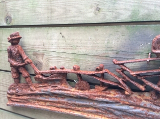 Wall decoration , cast iron fireplace plate farmer with horse and plow.