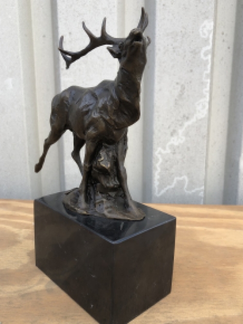 A bronze statue/sculpture of a deer