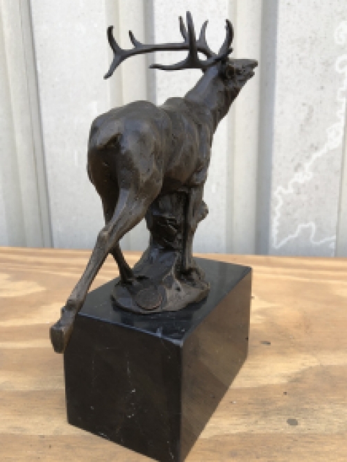 A bronze statue/sculpture of a deer