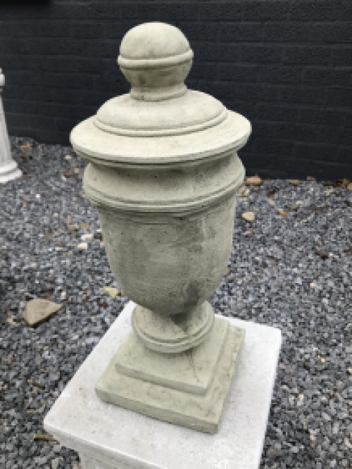 Een stenen urn, grafdecoratie in een grijze kleur