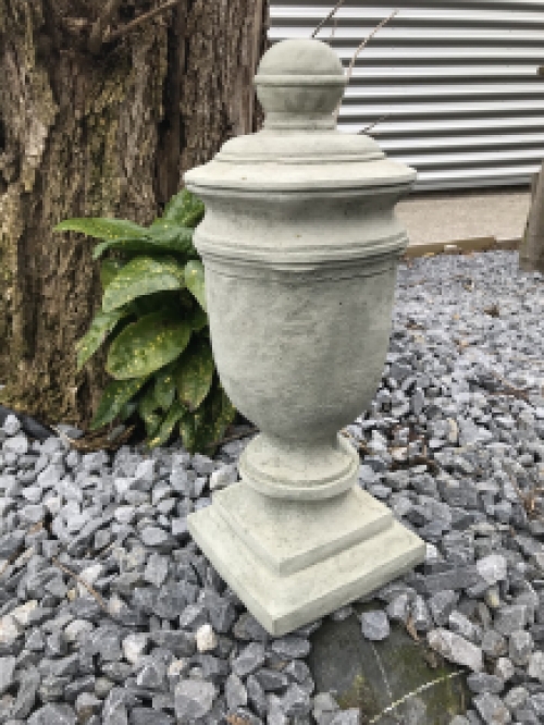 Een stenen urn, grafdecoratie in een grijze kleur