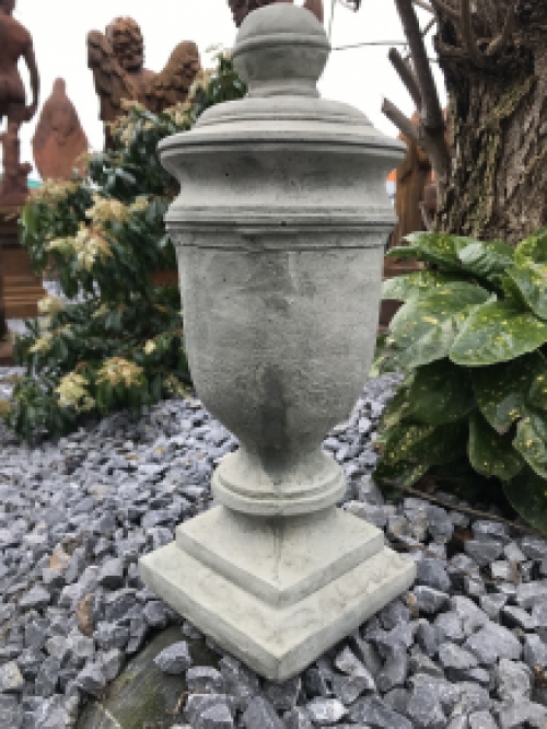 Een stenen urn, grafdecoratie in een grijze kleur