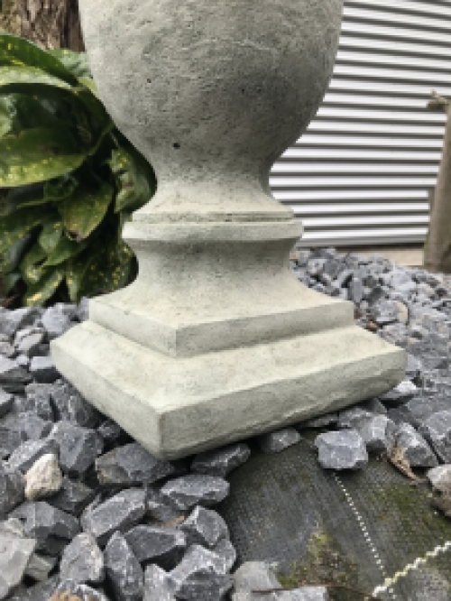 Een stenen urn, grafdecoratie in een grijze kleur
