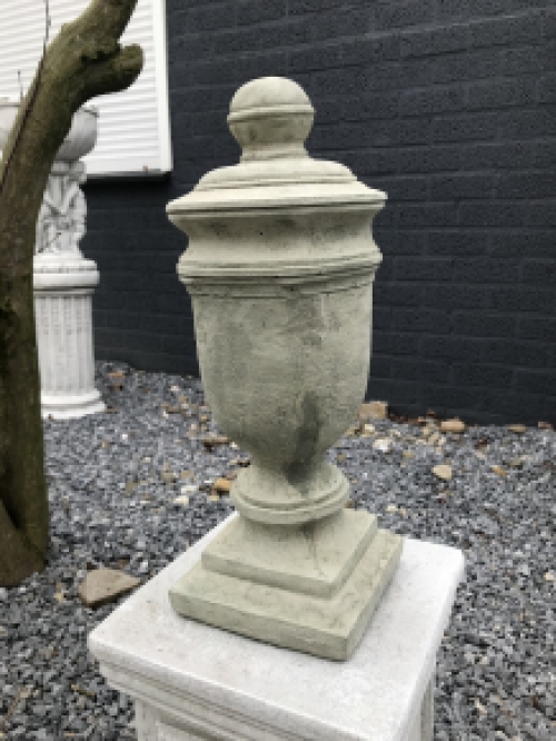 Een stenen urn, grafdecoratie in een grijze kleur