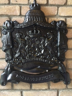 Zwaart gietijzeren wandornament, zwaar uitgevoerd met de spreuk: Je maintiendrai (ik zal handhaven), hofleverancier