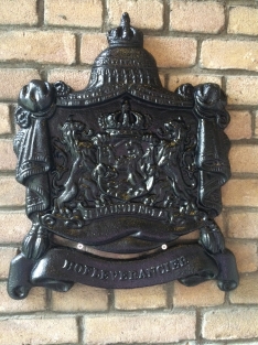 Zwaart gietijzeren wandornament, zwaar uitgevoerd met de spreuk: Je maintiendrai (ik zal handhaven), hofleverancier
