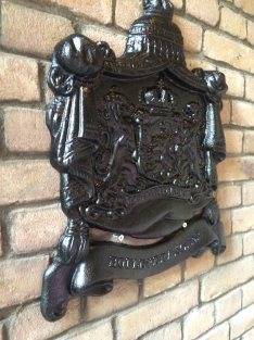 Zwaart gietijzeren wandornament, zwaar uitgevoerd met de spreuk: Je maintiendrai (ik zal handhaven), hofleverancier